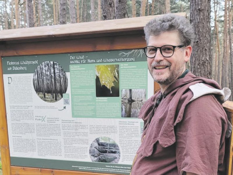 Dillenbergflüsterer Frank Flohr im Wald vor einer Schautafel
